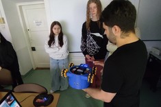 Dr inż. Dawid Kalandyk z Uczniami w Pracowni Wizji komputerowej. Dr Kalandyk prezentuje robota wykonanego w ramach KN GEST oraz jego możliwości.