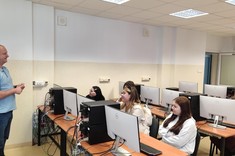 Dr inż. Andrzej Paszkiewicz z Uczniami w Laboratorium Sieci Komputerowych. Dr Paszkiewicz prezentuje urządzenia i opowiada o badaniach i zajęciach dydaktycznych realizowanych w laboratorium.