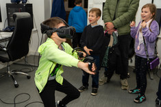 Sala VR, zwiedzający gra w grę przeznaczoną do wirtualnej rzeczywistości. Z tyłu widać innych zwiedzających.