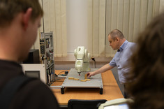 Laboratorium Automatyki, Robotyki i Sterowania. Na zdjęciu prowadzący pokazuje działanie robota ramiennego z wykorzystaniem drewnianych bloków.