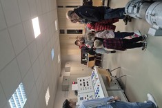 Laboratorium maszyn elektrycznych. Prowadzący rozmawia z uczestnikami.