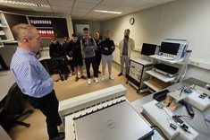 dr inż. Wiesław Sabat z Uczniami prezentujący urządzenia pomiarowe w bocznym laboratorium EMC,