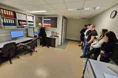 Dr inż. Wiesław Sabat z Uczniami oraz studentką Julią Semak. Dr Sabat prezentuje badania prowadzone w komorze EMC. Widok na boczne laboratorium. Inne ujęcie.