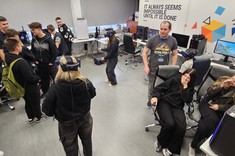 mgr inż. Michał Ćmil z Uczniami w laboratorium wirtualnej rzeczywistości. Uczniowie zaznajamiają się z VR mając nałożone gogle,