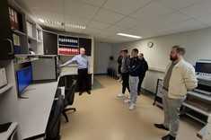 dr inż. Sabat z Uczniami w laboratorium bocznym EMC. Pokazuje sprzęt odpowiedzialny za sterowanie komorą.